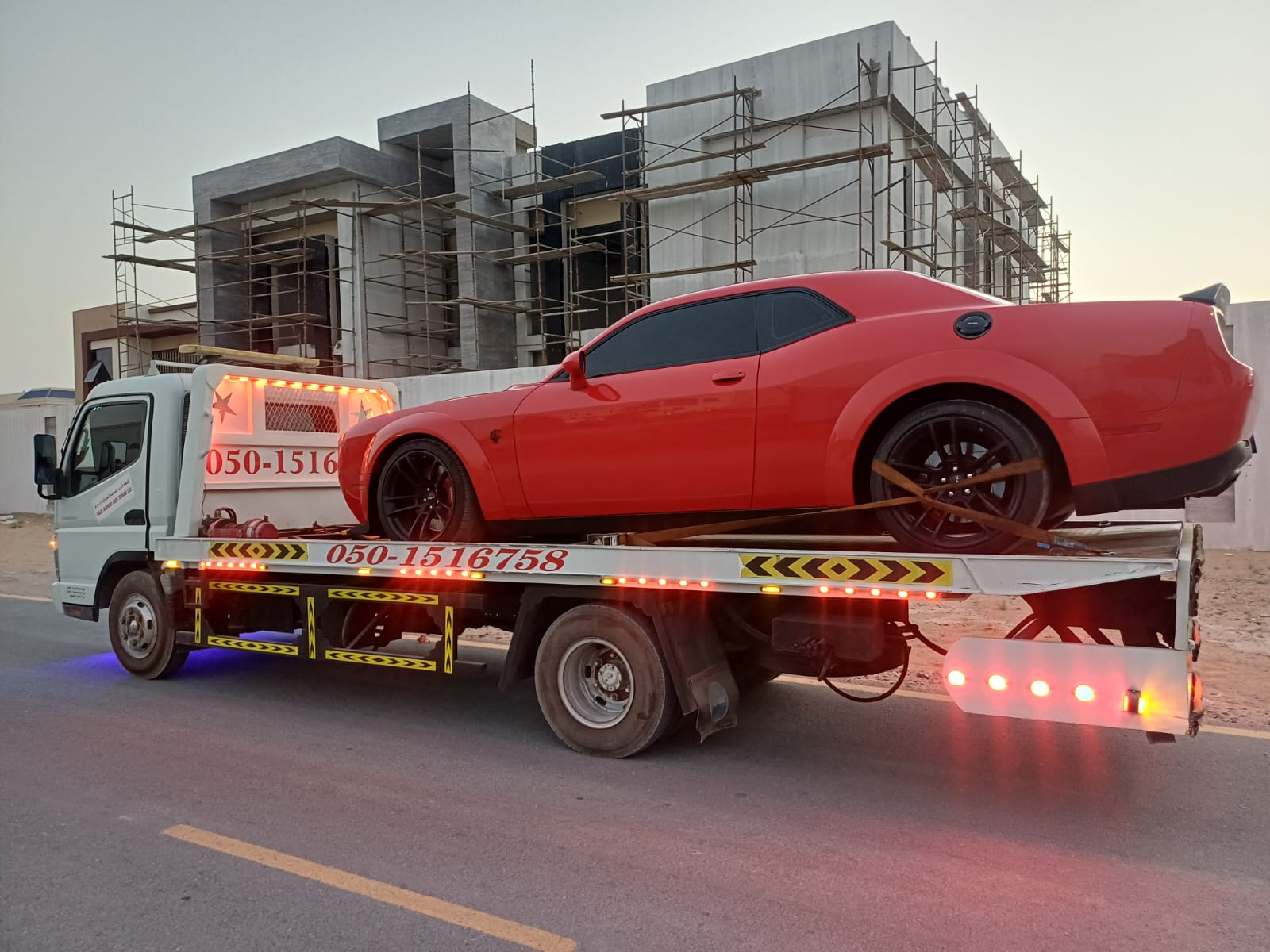 Red Dodge flatbed towing in Sharjah